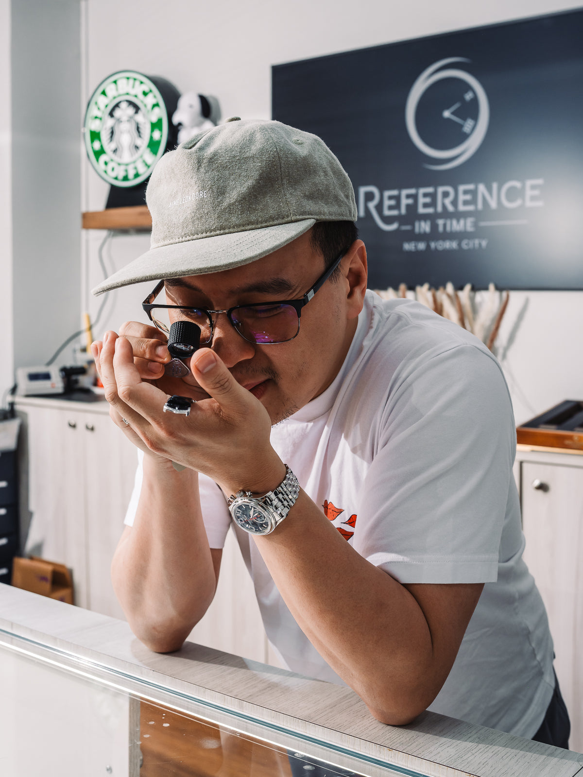 A Reference in Time specialist looking through a loupe at the showroom counter